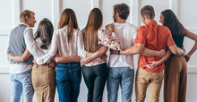 Group Of Young People Hugging Together Rear View