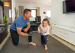 © SB Arts Media - COVID-19 Outrbreak. Father and daughter exercising together at home during coronavirus quarantine