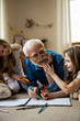 © Yakobchuk Olena - Twin girls having fun with mirthful grandfather stock photo
