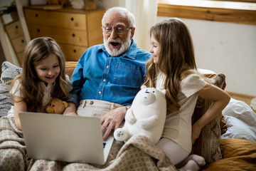 Wall Mural - Funny grandfather excited by modern technologies stock photo