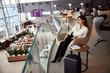 Beautiful young woman sitting in chair in departure lounge