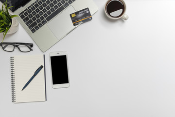 Wall Mural - white office desk table with laptop, and smartphone and pen on a notebook, credit card shopping onli
