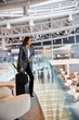 © Yakobchuk Olena - Stylish lady standing on second floor of airport waiting room