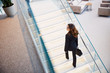 © Yakobchuk Olena - Stylish young woman climbing stairs in business center