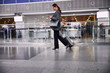 © Yakobchuk Olena - Beautiful businesswoman with luggage walking in airport