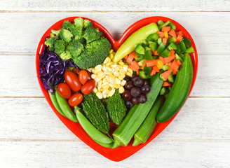 Wall Mural - Healthy food selection clean eating for heart life cholesterol diet health concept Fresh salad fruit and green vegetables mixed various beans nuts grain on heart plate for healthy food vegan cooking