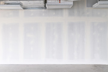 drywall background during interior renovation with open ceiling system work. drywall is gypsum wall 