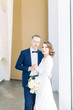 © pavelvozmischev - The bride and groom's romantic photo shoot. The newlyweds are happy together. Stylish modern couple in a light interior.