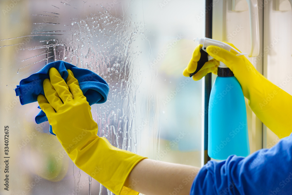 Gloved hand cleaning window rag and spray - obrazy, fototapety, plakaty 