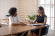 © fizkes - African woman applicant vacancy candidate passing job interview answers on questions interacting with HR manager caucasian businesswoman meet in office. Financial advisor listen bank client concept
