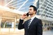 © Have a nice day  - portrait of a caucasian business man using his phone for internet, messaging, call, texting and socializing, handsome looking and wearing a suit and tie within an urban city structure in background