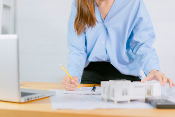 Wall Mural - Asian architect man and woman working with laptop and blueprints,engineer inspection in workplace for architectural plan,sketching a construction project ,selective focus,Business concept