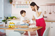 © Olena Bloshchynska - Mother cooking with her son in kitchen at home.