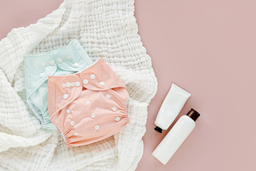 Baby set of cloth diaper with insert laying  and muslin swaddle blanket.  Set of newborn accessories. Flat lay, top view