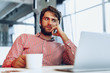 © fotofabrika - Puzzled thoughtful businessman sitting at his working table in an office. Business concept