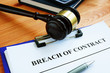 Breach of contract papers with pen and gavel.