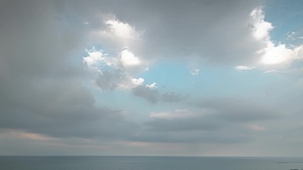 Wall Mural - A vertical pan down aerial timelapse of fluffy white clouds filling a blue sky and then disappearing over Lake Michigan on the north side of Chicago and Foster Beach during sunset.