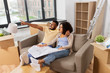 © Syda Productions - mortgage, people and real estate concept - happy african american couple with boxes and blueprint moving to new home