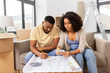 © Syda Productions - mortgage, moving and real estate concept - african american couple with blueprint and calculator counting money for repair costs to new home