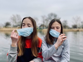 two teenage girls sisters in medical masks