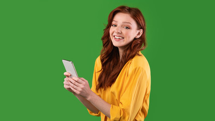 Girl Using Cellphone Texting In Social Media Standing, Studio Shot