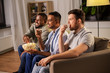 © Syda Productions - friendship, leisure and people concept - happy male friends with popcorn watching tv at home at night