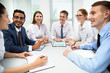 © chagin - Multy-ethnic group of young business people working with computer at office