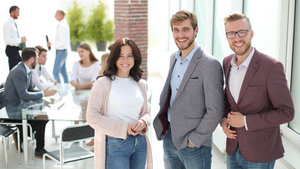 three young employees standing in a modern office.