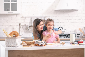 Mom and daughter prepare pastries in the kitchen.