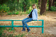 © mihail_pustovit - portrait a stylish pregnant woman walking in jeans in the autumn park. happy blonde pregnant woman touches the belly on nature in sunny day. 9 months of Healthy Pregnancy. Woman waiting a childbirth
