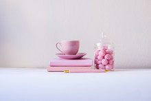 Feminine Workspace, Pink Notebook, Pink Cup, Pink Candies On The White Background. Back To School Concept. Girls Desk Composition Supplies. Pink, Isolated, Flat Lay, Copy Space