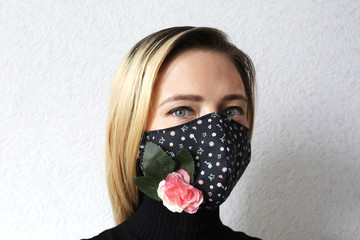 Woman wearing face mask decorated with flowers. Stylish handmade cotton mask. 