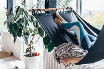 Wall Mural - Woman is lying at home in a hammock and resting