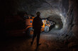 Man miner in underground quartz mine tunnel with scoop machine