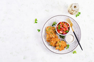 Homemade grilled chicken with green peas patties on a plate with tomatoes salad. Chicken cutlets. Top view, overhead