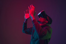 African-american Man's Portrait In VR-headset Isolated On Gradient Studio Background In Neon Light. Beautiful Male Model. Concept Of Human Emotions, Facial Expression, Sales, Ad, Inclusion, Tech.