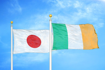 Wall Mural - Japan and Ireland two flags on flagpoles and blue cloudy sky
