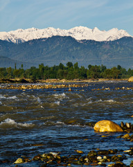 Wall Mural - Snow covered mountains with River in foreground in Kashmir, India, mountain River in Valley