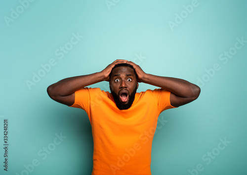 Cuadros en Lienzo Amazed and shocked expression of a boy over cyan background