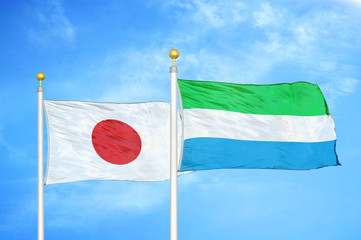 Japan and Sierra Leone two flags on flagpoles and blue cloudy sky