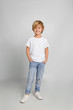 © New Africa - Cute little boy in casual outfit on light grey background
