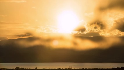 Wall Mural - Time lapse of sun setting through glowing clouds over Utah Lake.
