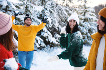 Wall Mural - Happy friends playing snowballs outdoors. Winter vacation