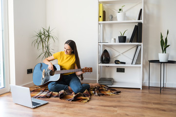 A woman watches video tutorial on guitar playing