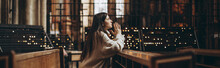 A Young Pretty Woman Came To The Temple To Pray To God. The Parishioner Of The Church Sits On A Bench With Her Hands Folded For Prayer And Heartily Prays. Copy Space