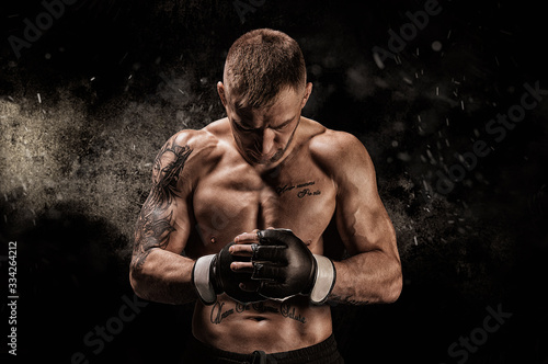 Cuadros en Lienzo Mixed martial artist posing on a black background