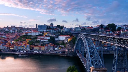 Canvas Print - Porto, Portugal. Aerial view of Ribeira area in Porto, Portugal during a sunny evening with river, colorful buildings and bridge. Time-lapse from day to night