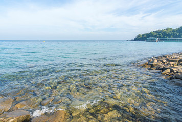 Wall Mural - Rock beach with clear water and blue skies