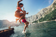 © Mediteraneo - Group of friends jumping off the pier into the sea. Selective focus
