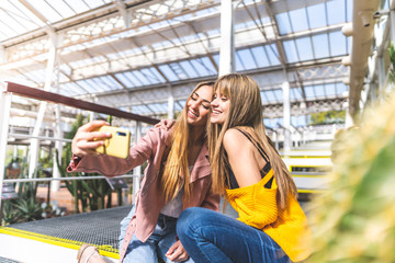 Wall Mural - Two Female Friends Taking a Selfie Indoors.